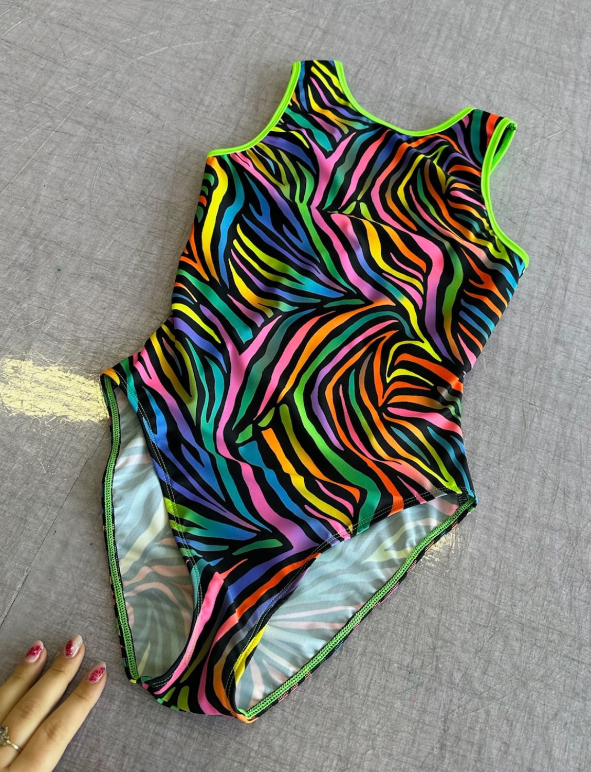 Rainbow zebra print lycra bodysuit with high neck and high leg.
