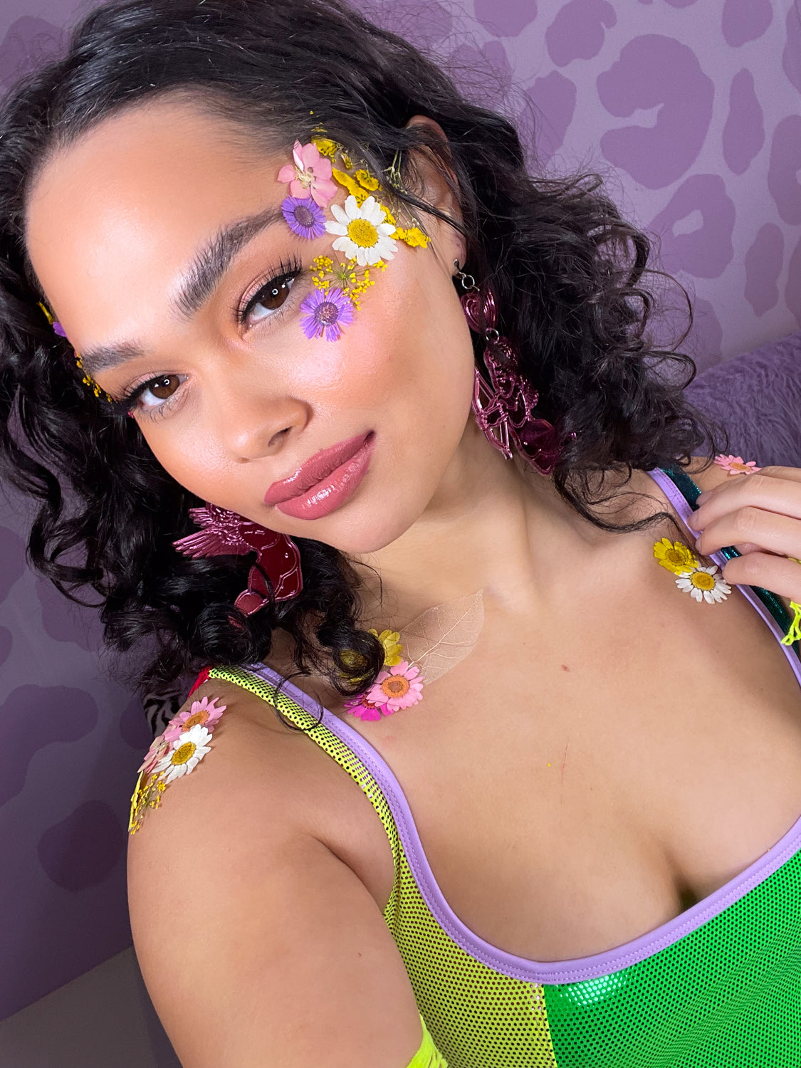 woman posing with dried flowers on her face and body