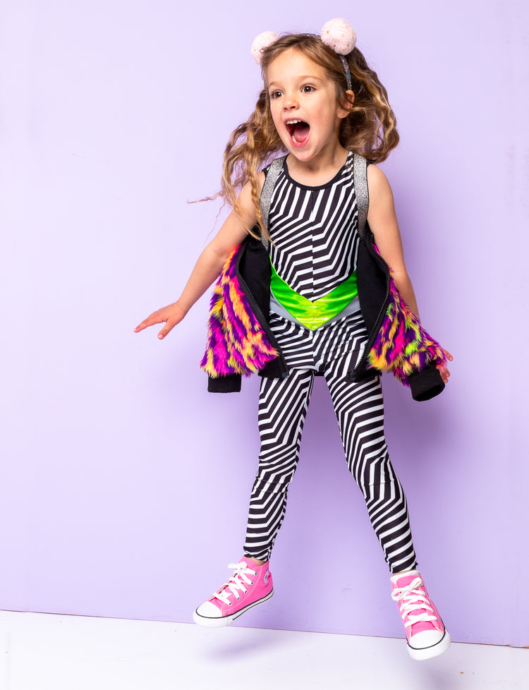 Girl jumping in the air wearing a black and white striped catsuit.