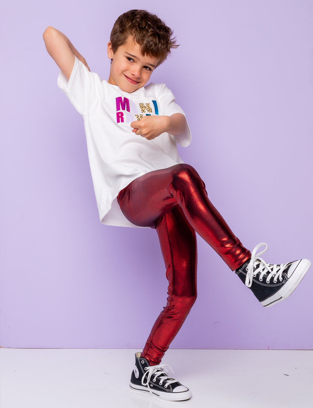 Boy modelling shiny red leggings and t-shirt that says 'mini raver'.