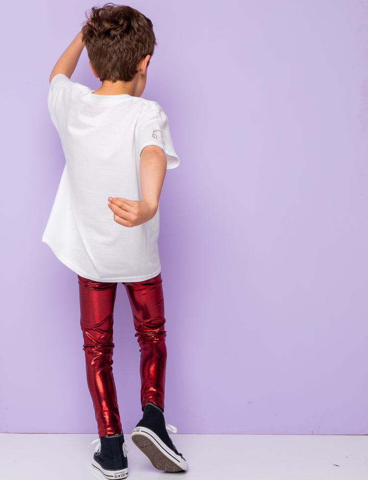 Back view of a boy wearing shiny red leggings and a white t-shirt.