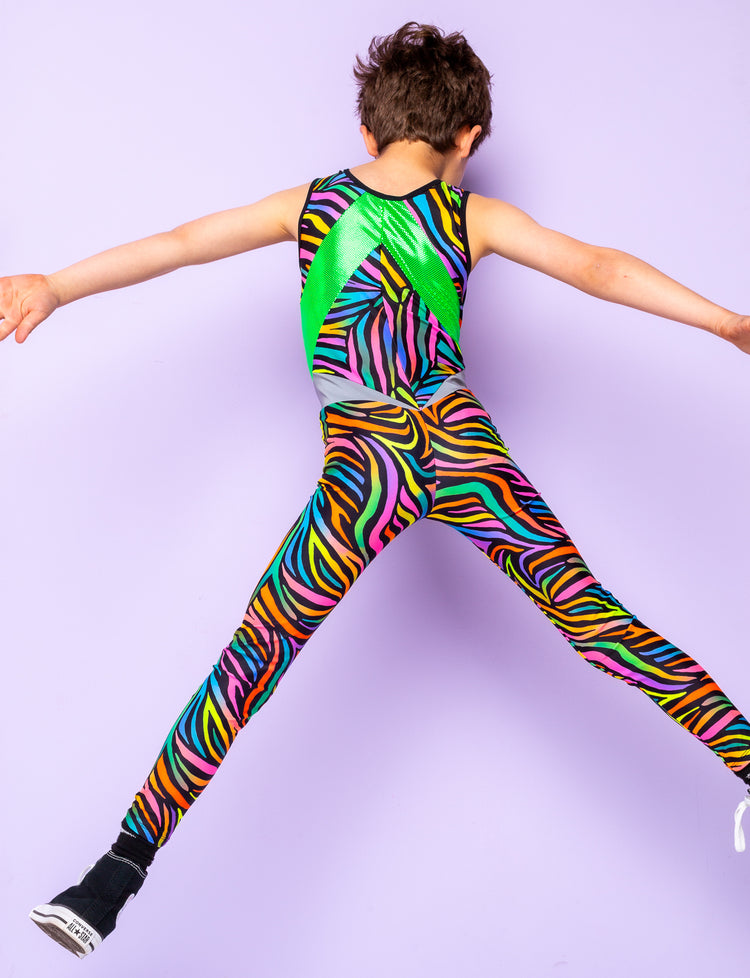 Back view of a boy jumping in the air wearing a multicoloured zebra print catsuit.
