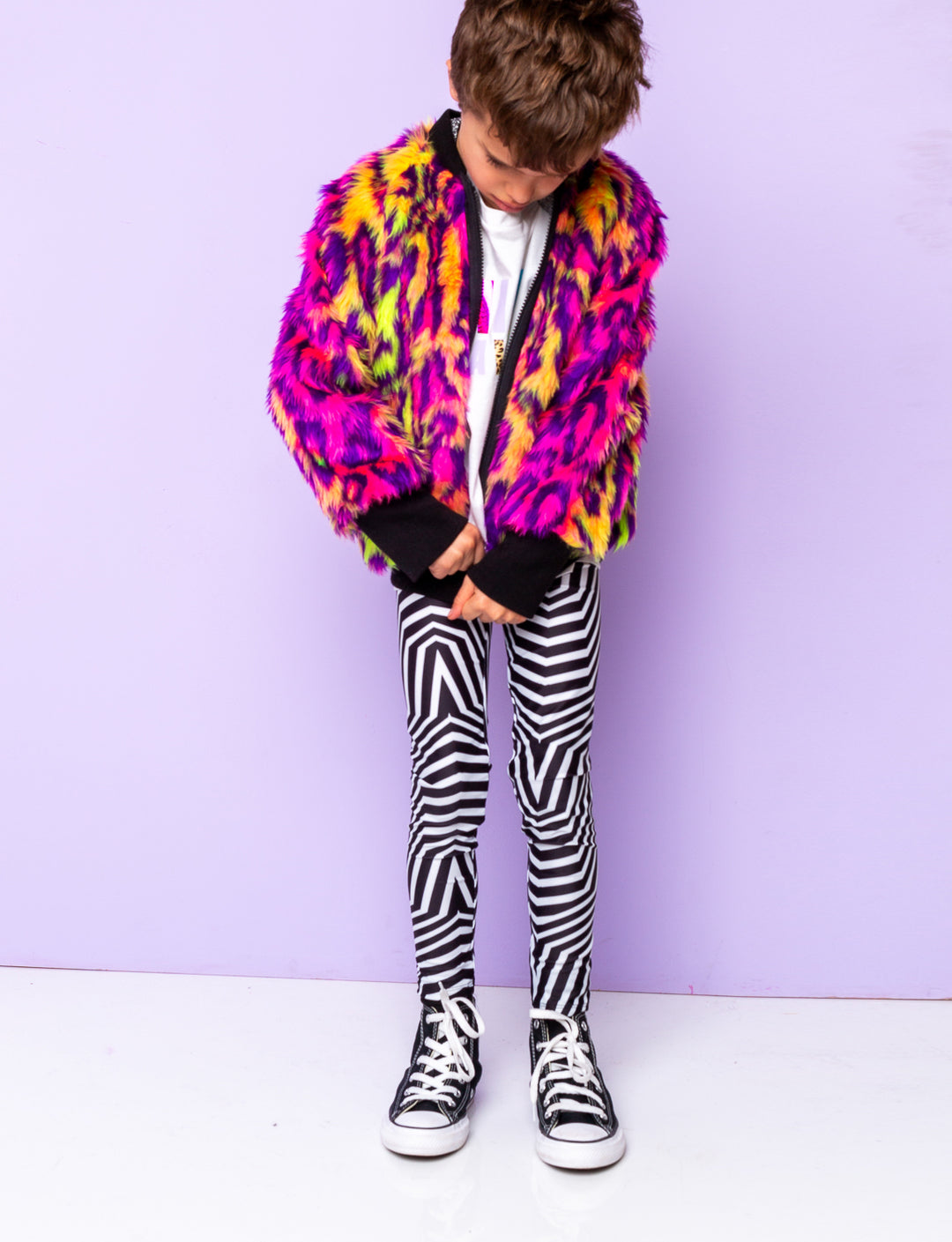 Boy modelling black and white geometric printed leggings with a fur animal print jacket.