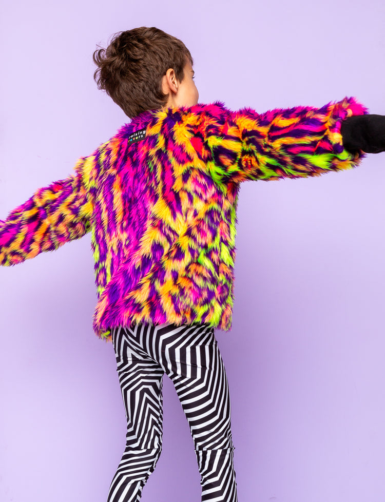 Back view of a boy modelling black and white geometric printed leggings with a fur animal print jacket.