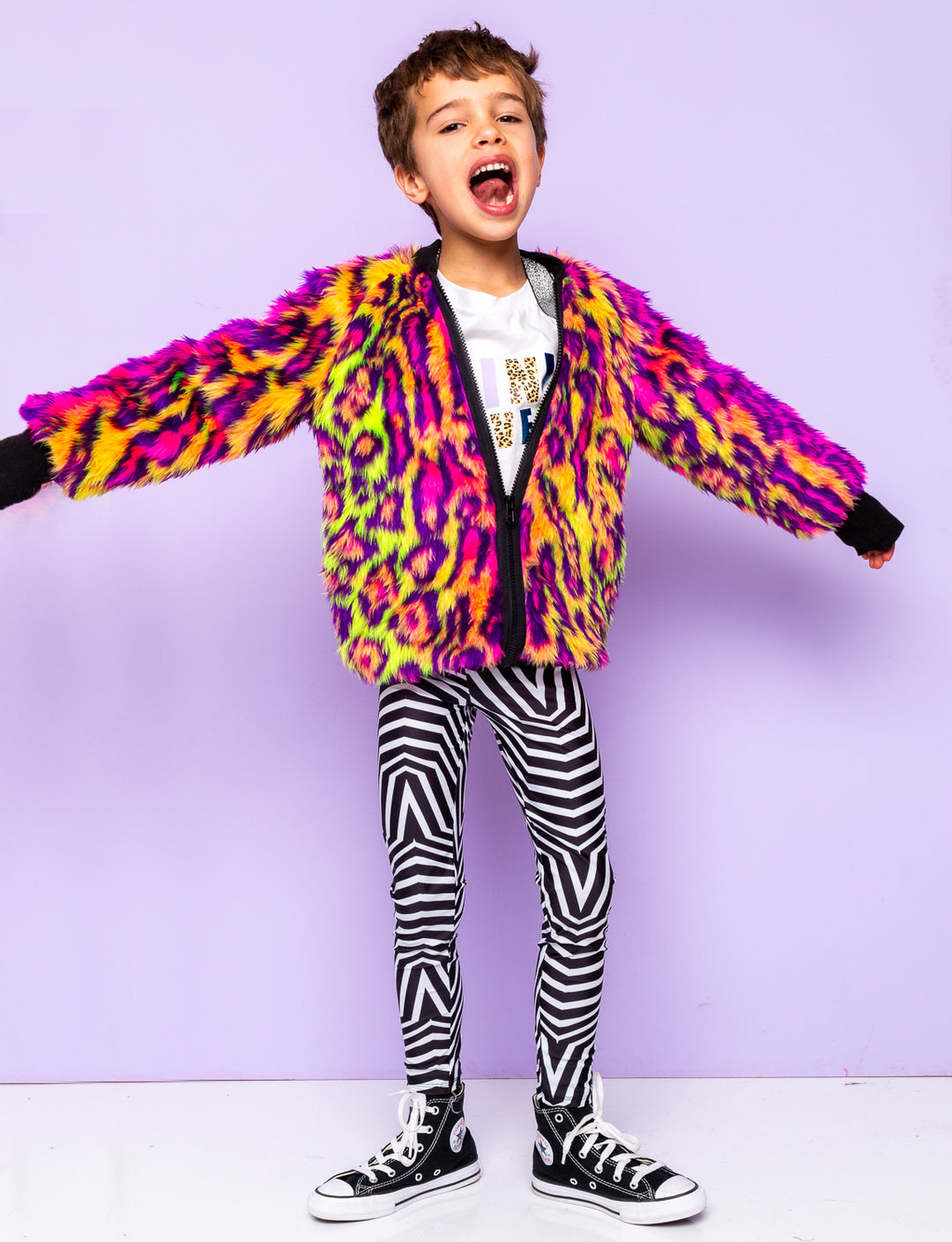 Boy modelling black and white geometric printed leggings with a fur animal print jacket.