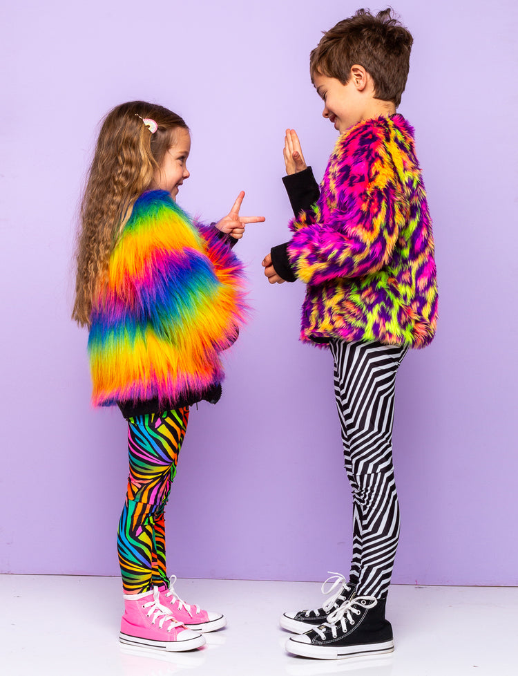Girl and boy modelling patterned festival leggings and rainbow fur jackets.