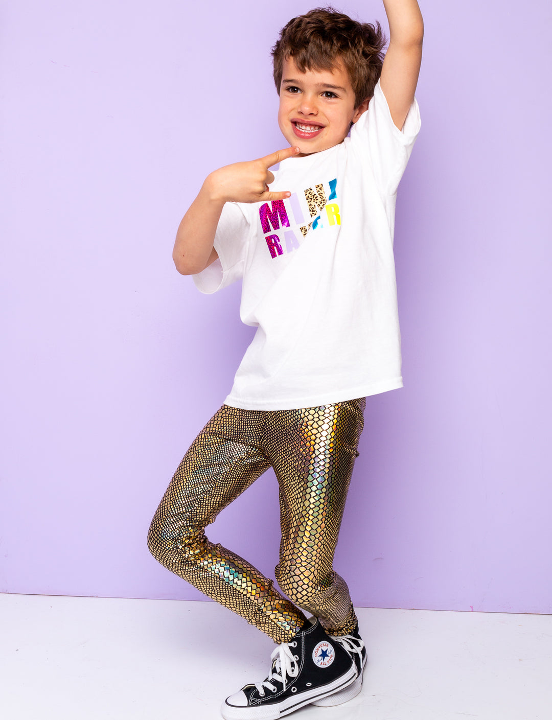 Boy wearing gold holographic snakeskin leggings.