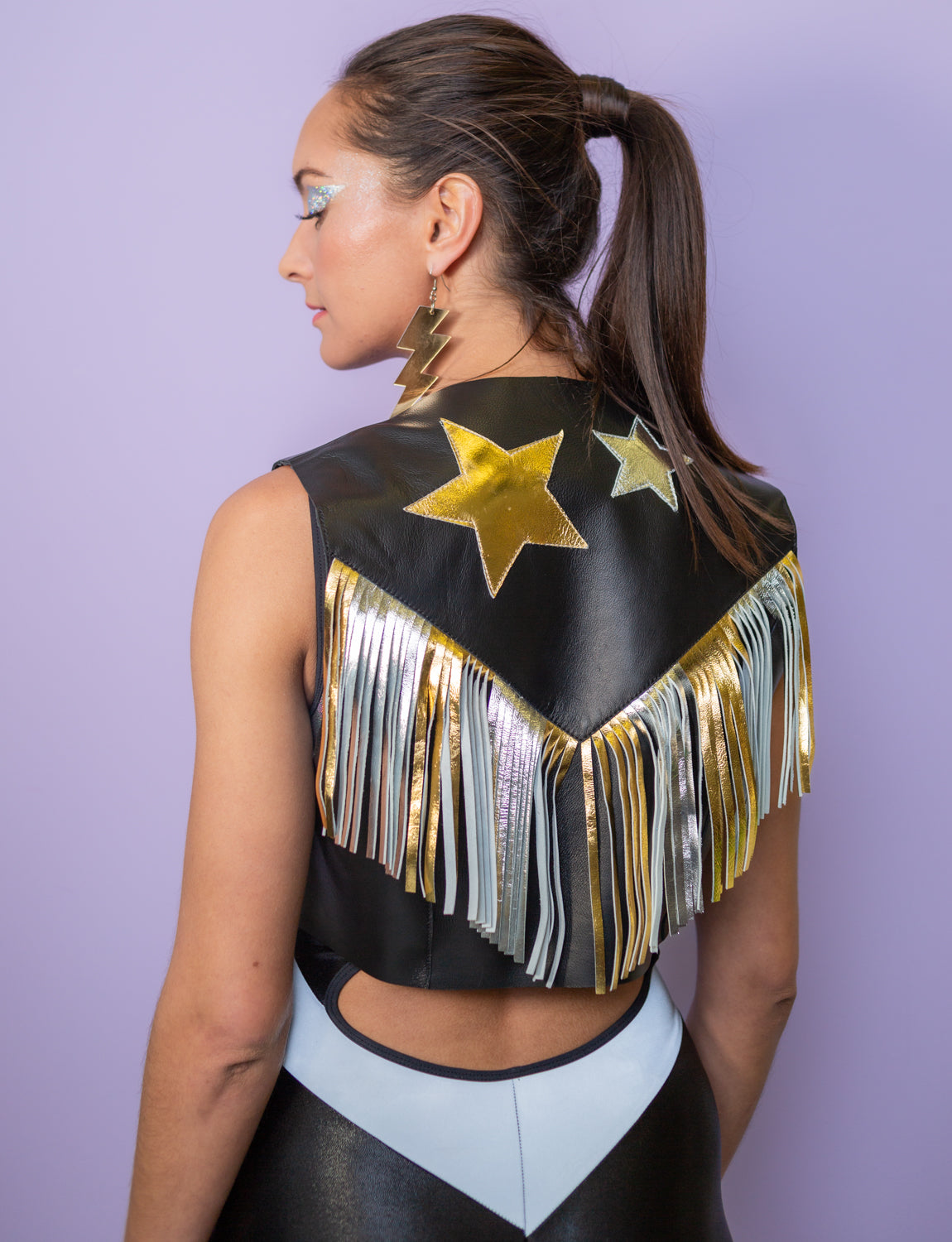Back view of a woman wearing a fringed waistcoat with stars on the back.