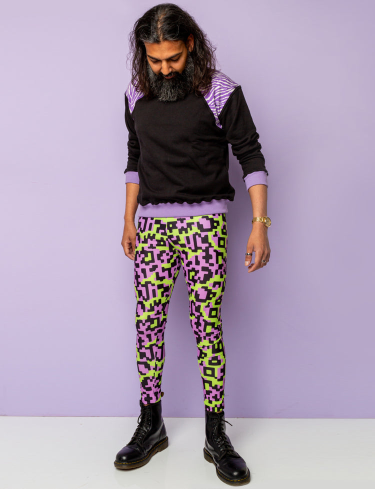 Man wearing funky festival leggings with a black and purple zebra print sweatshirt.