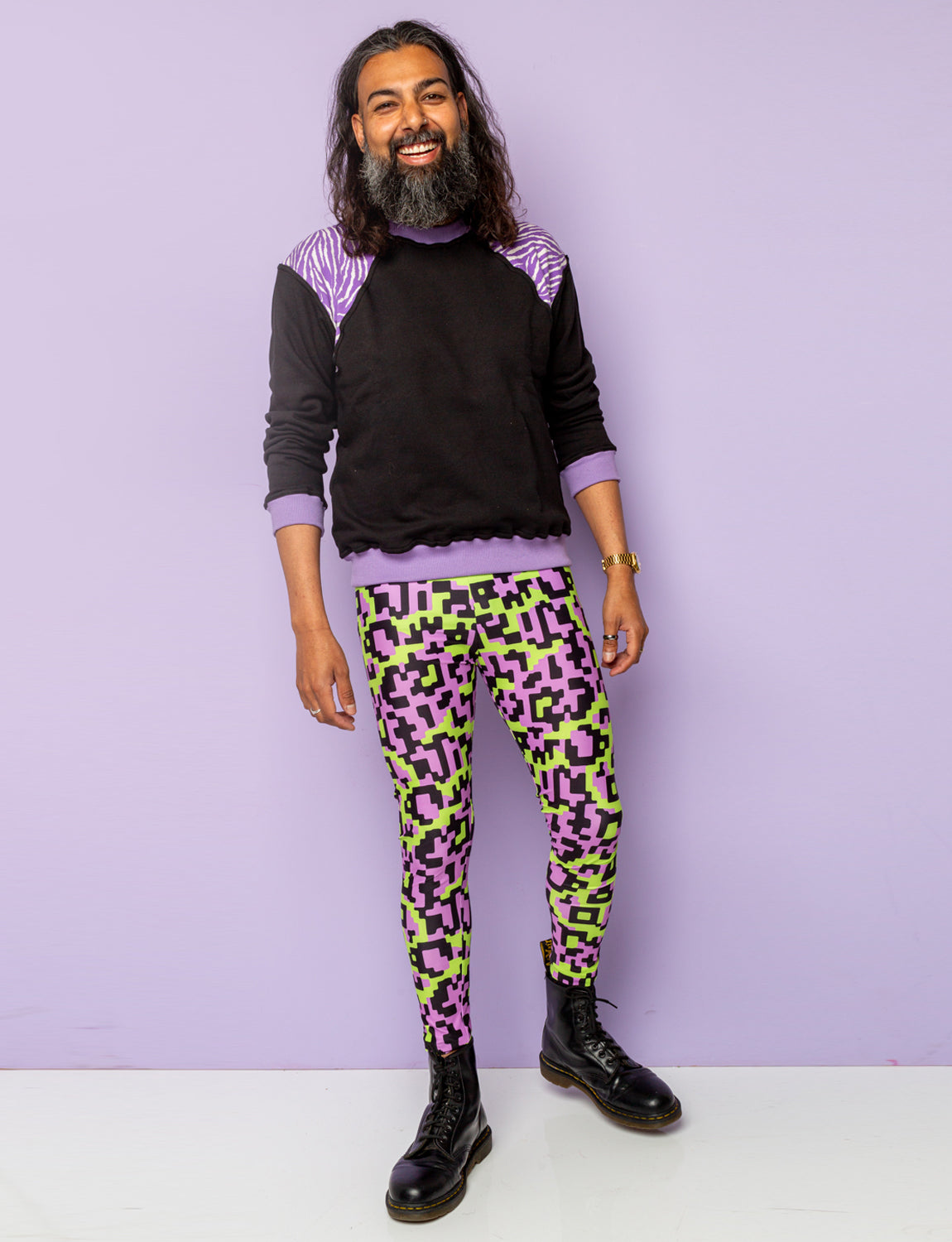 Man wearing funky festival leggings with a black and purple zebra print sweatshirt.