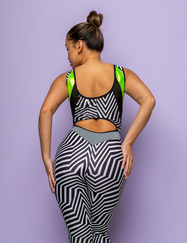 Back view of a woman modelling a black and white geometric printed lycra catsuit with peekaboo back detail.
