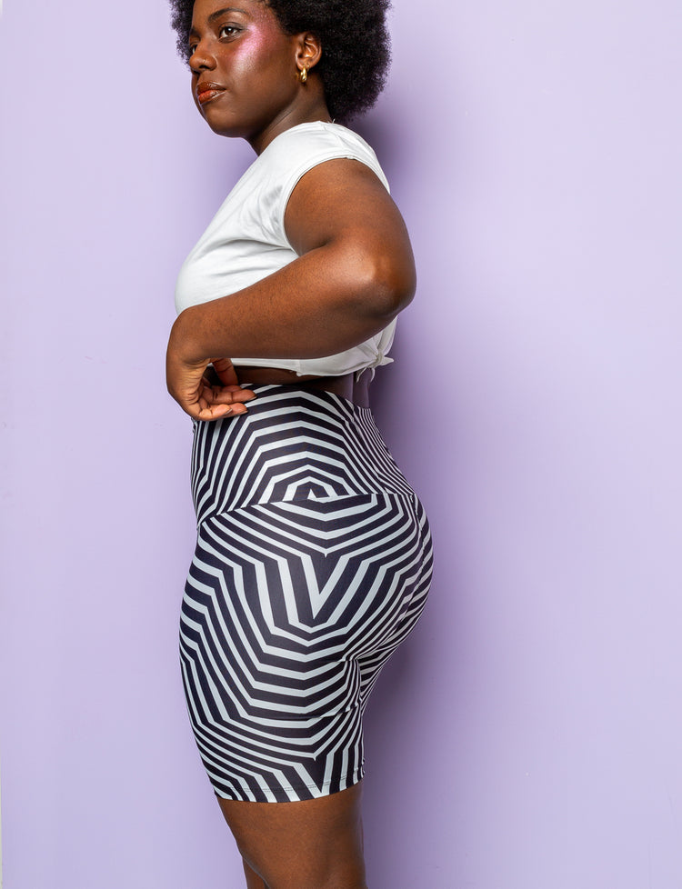 Side view of a woman wearing funky black and white patterned lycra cycling shorts.