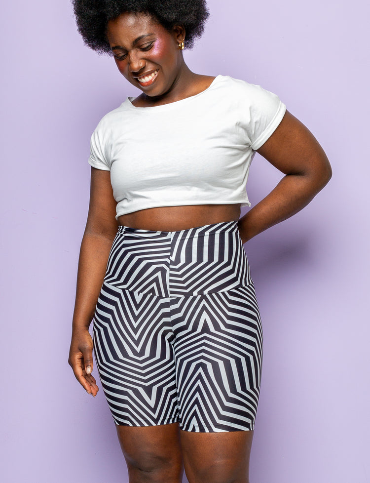 Woman wearing geometric black and white patterned lycra cycling shorts.