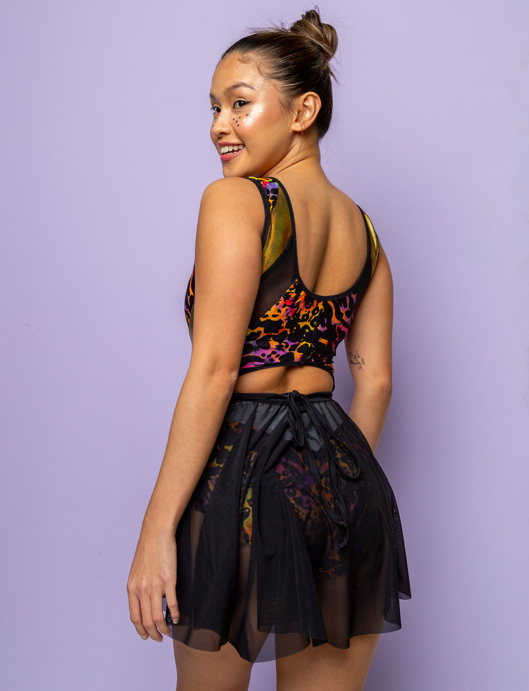 Model wearing a purple leopard print lycra bodysuit with black mesh skirt.