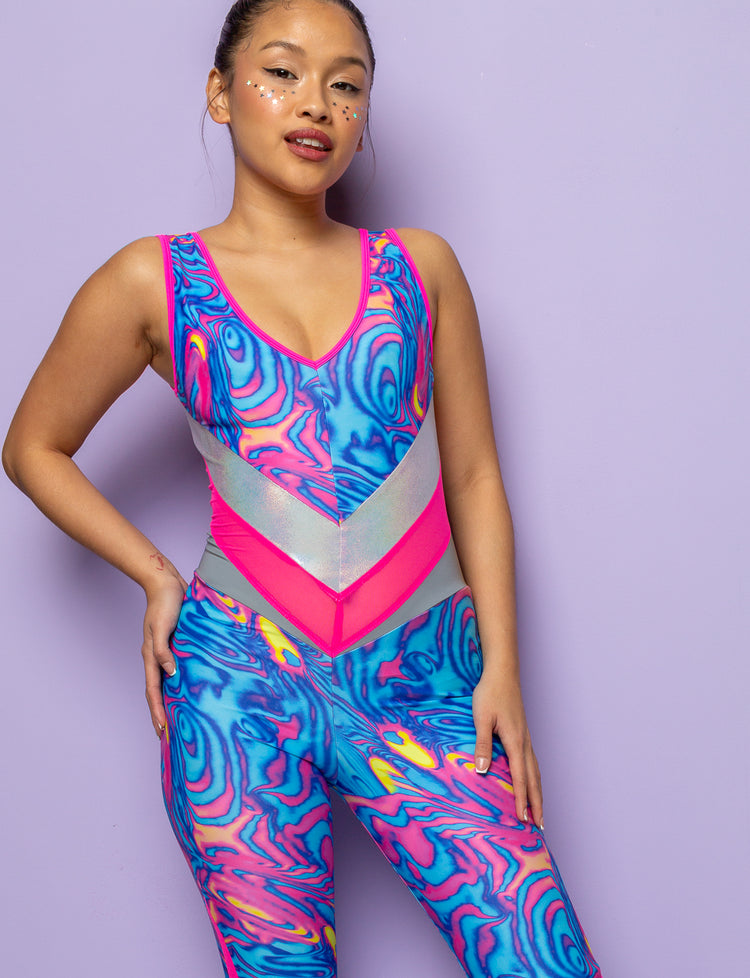 Model wearing a swirly pink and blue patterned lycra catsuit with mesh panels.