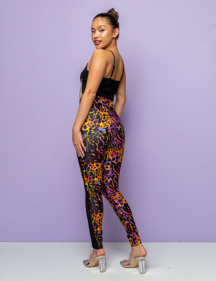 Back view of a woman wearing purple and yellow leopard print leggings.