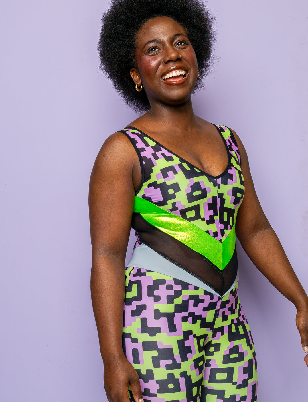 Woman wearing a lilac and lime green patterned lycra catsuit.