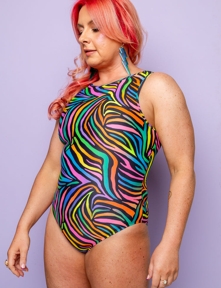 Woman wearing a rainbow zebra print bodysuit.