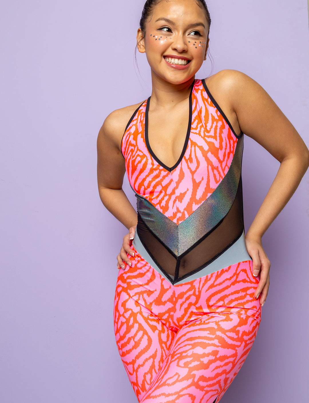 Woman wearing a pink zebra print catsuit with mesh panels.
