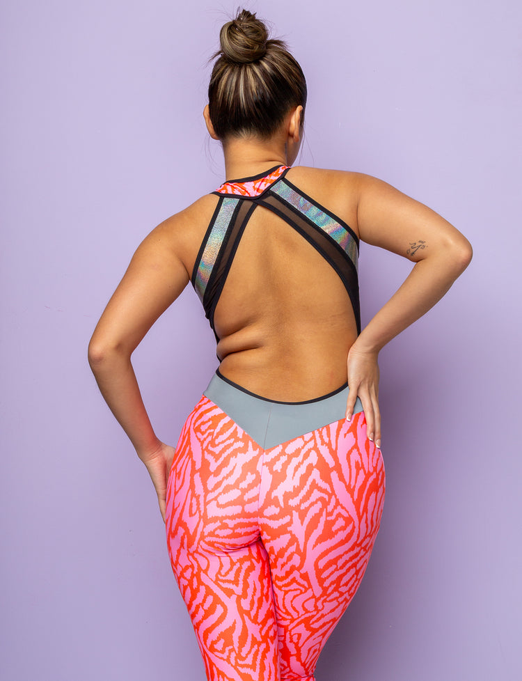 Back view of woman wearing a pink zebra print catsuit with mesh panels and backless detail.