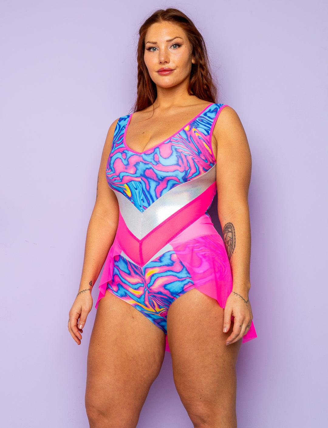 Woman wearing a pink and blue swirly print lycra bodysuit with pink mesh skirt.
