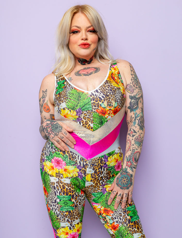 Woman with tattoos wearing a tropical leopard print lycra catsuit with pink panels.