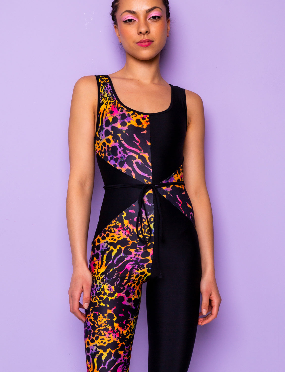 Woman modelling a purple leopard print catsuit with contrasting black panels.