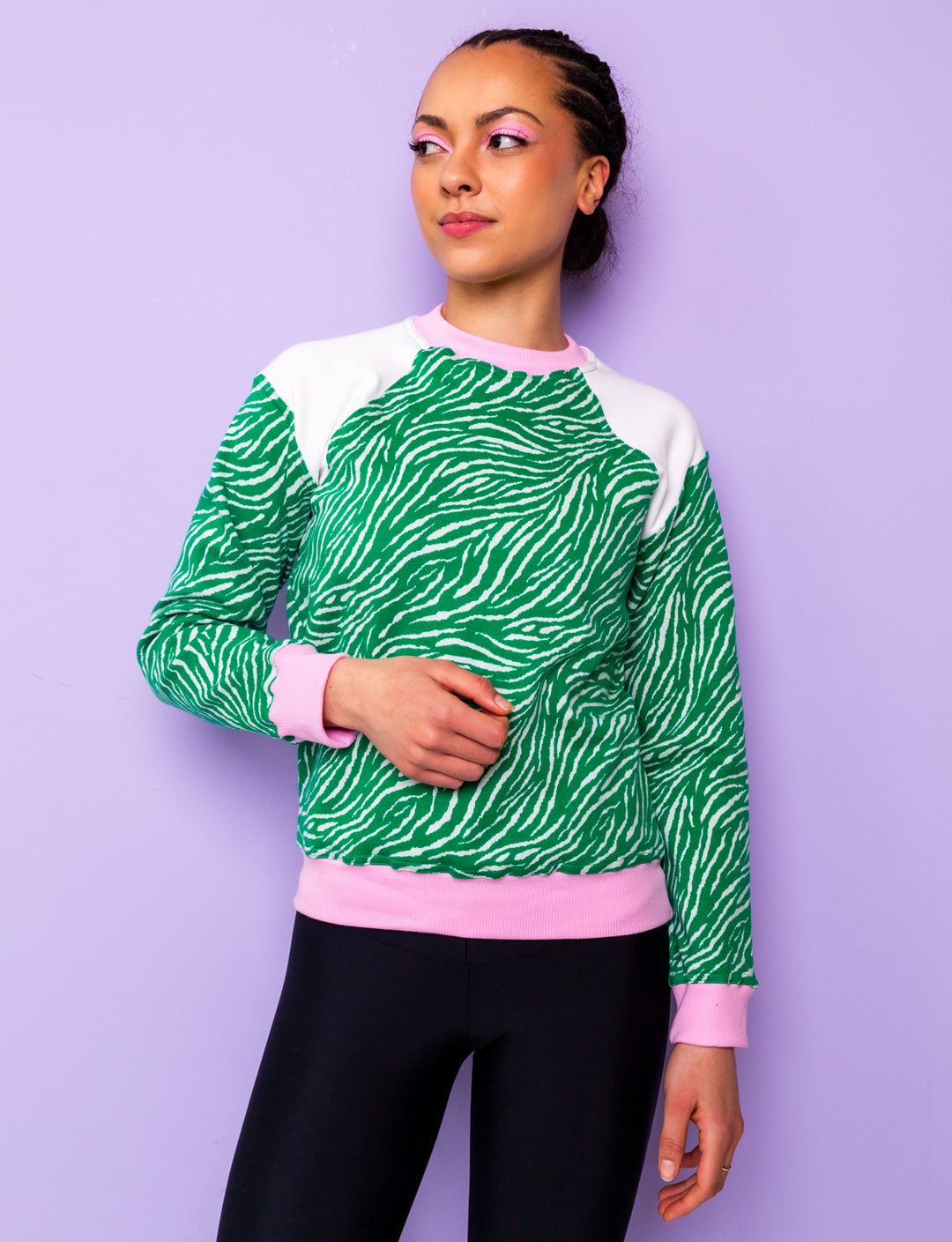 woman wearing a green zebra print sweatshirt with pink and white panels