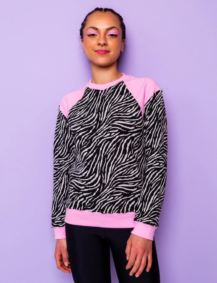 woman wearing a black and white zebra print sweatshirt with pink panels