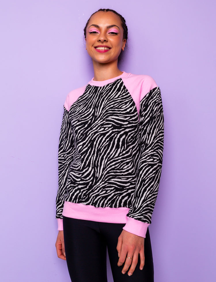woman wearing a black and white zebra print sweatshirt with pink panels