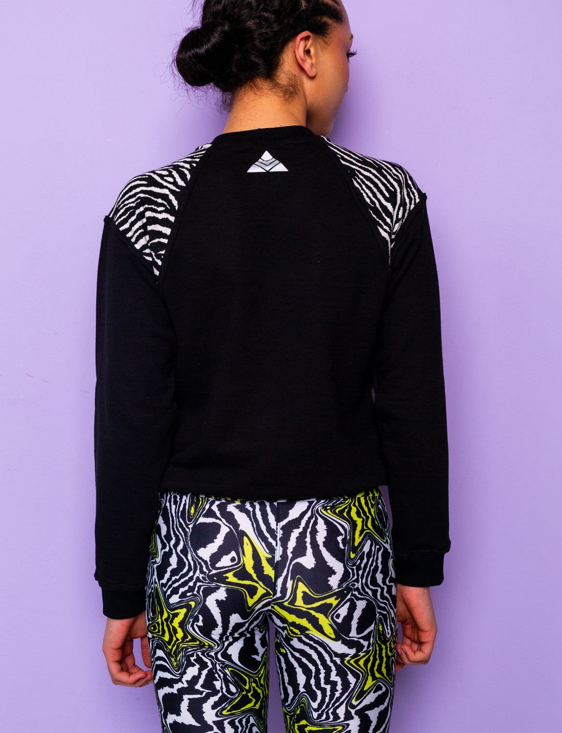 back of a woman wearing a black sweatshirt with black and white zebra print shoulders
