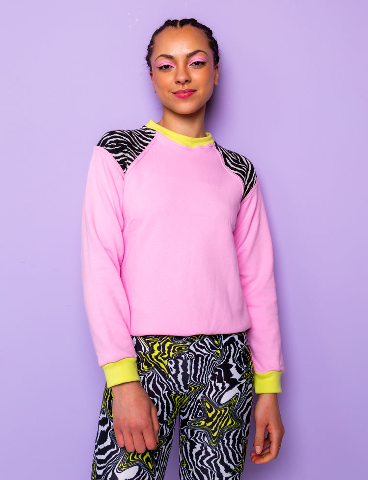 woman wearing a pink sweatshirt with zebra prints shoulders and star patterned leggings