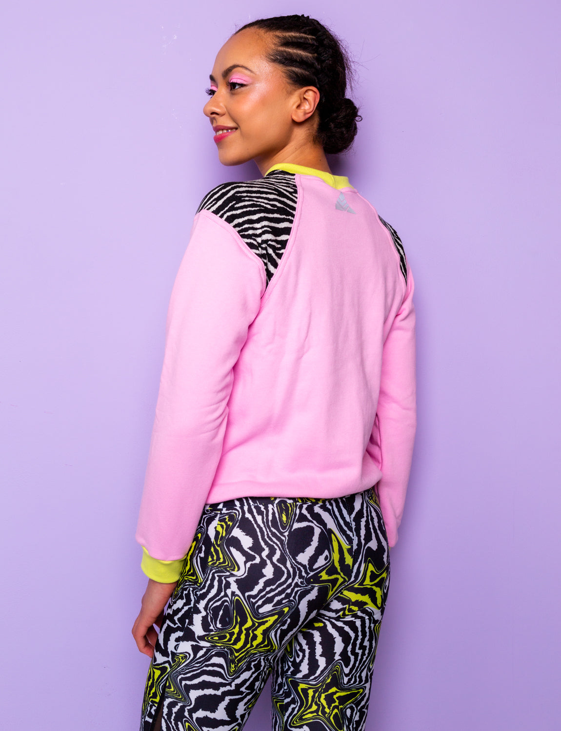 side view of a woman wearing a pink sweatshirt with zebra prints shoulders