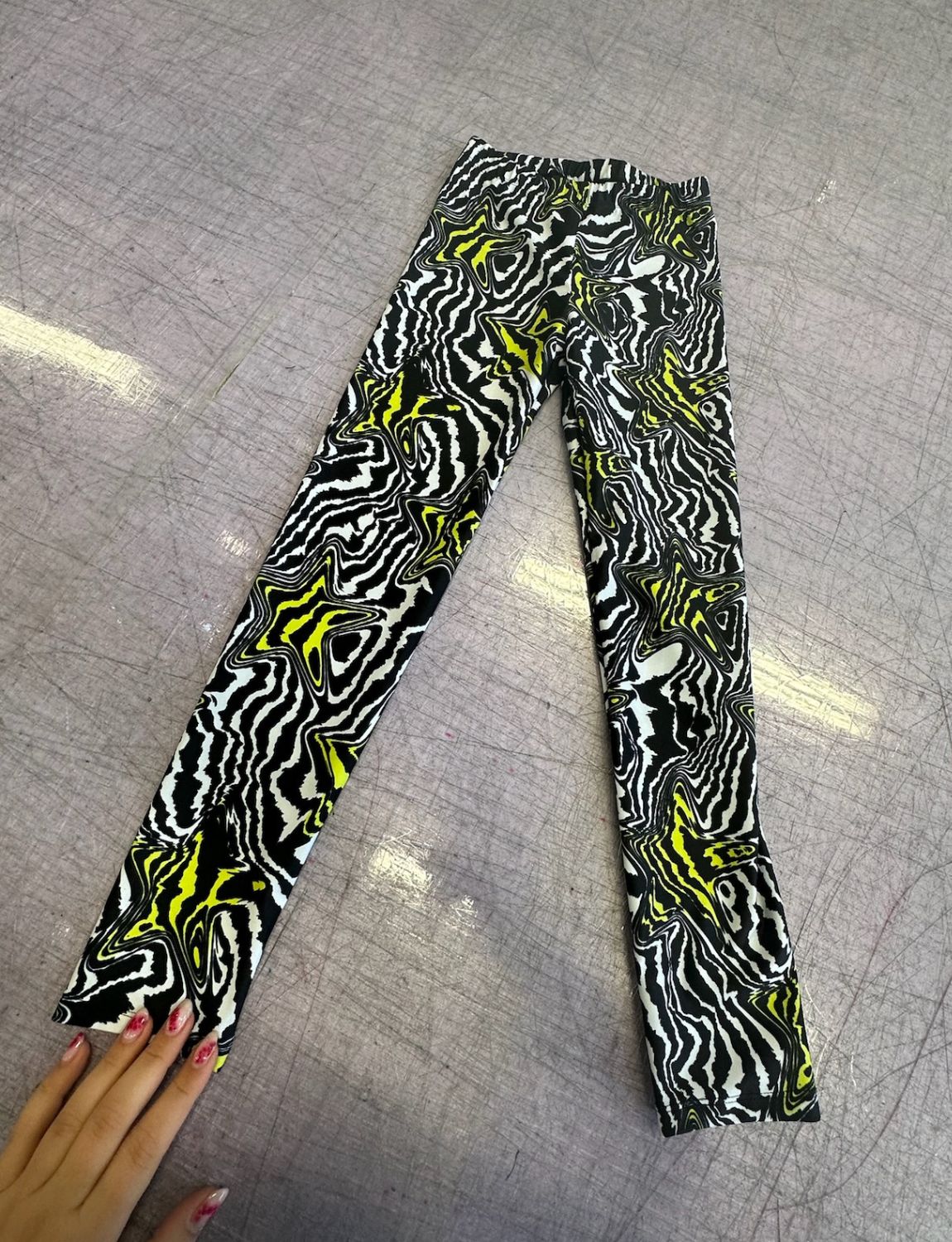 Kids lycra leggings in a black and white swirly pattern with yellow stars.