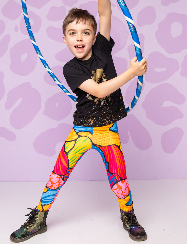 Boy wearing colourful leggings with Dr Martin boots and a black t-shirt
