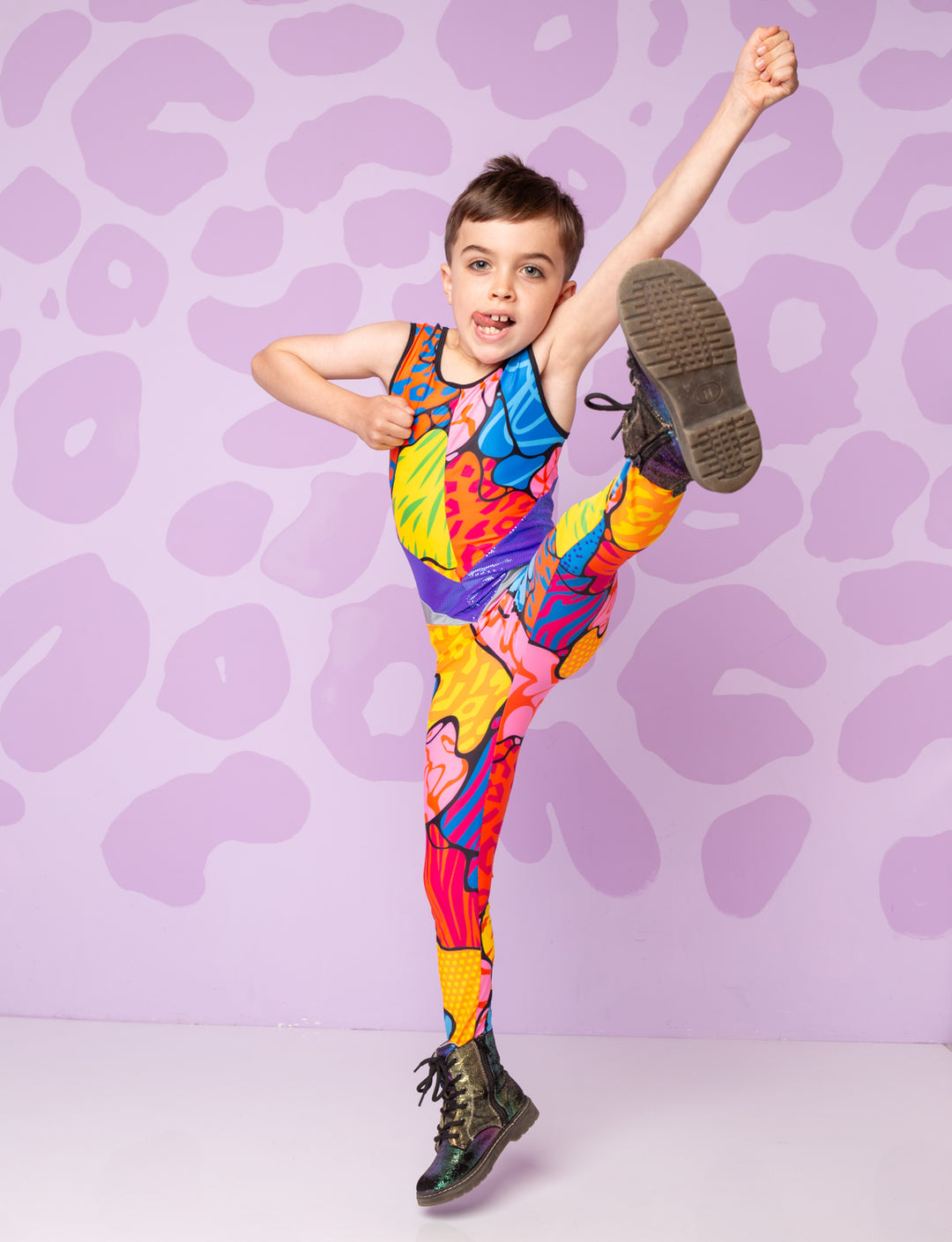 Boy doing a high kick wearing a colourful patterned catsuit