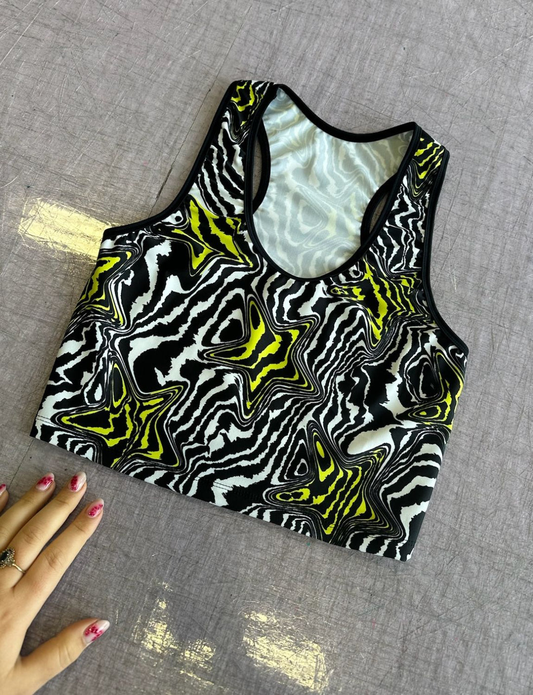 Lycra racerback crop top in black and white swirly print with yellow stars.