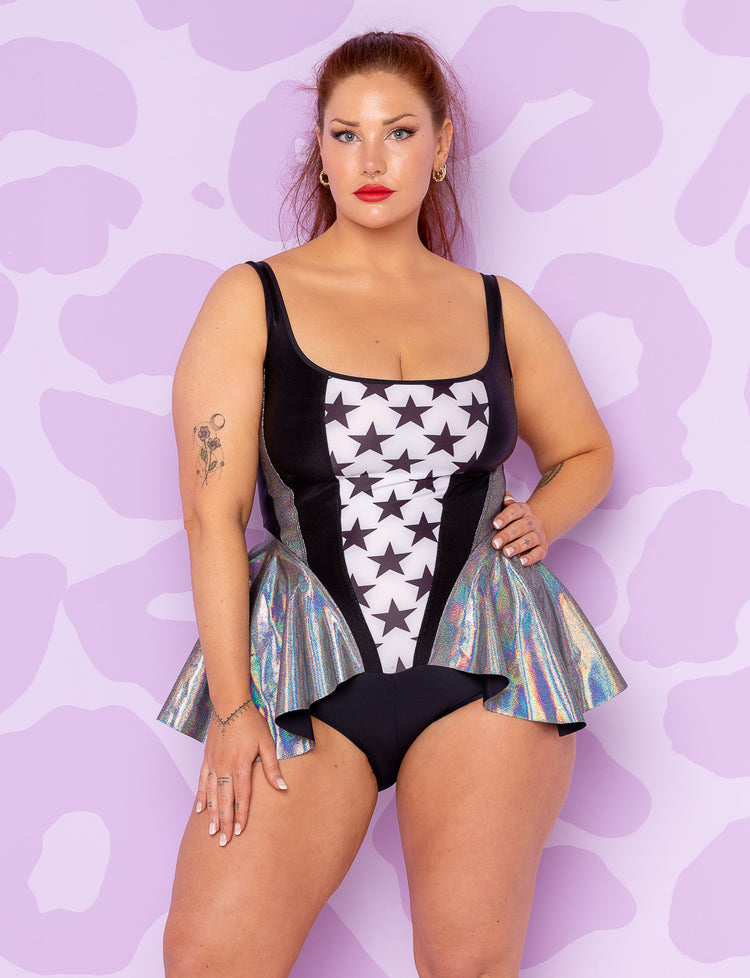lady wearing black and white bodysuit with stars with silver holographic peplum